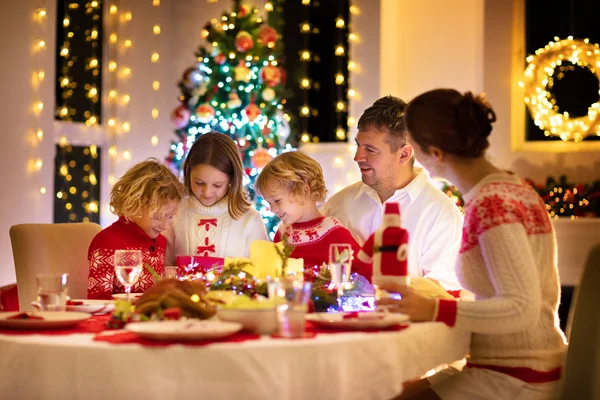 Çocuklu bir aile Noel yemeğini ağaçta yiyor. — Stok fotoğraf