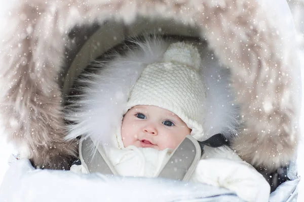 Baby in kinderwagen in de winter sneeuw. Kind in kinderwagen. — Stockfoto