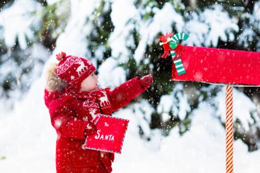 Çocuk ile Noel babaya mektup vasıl Noel posta kutusu karda