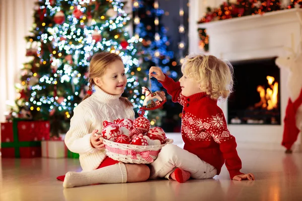 子供たちはクリスマスツリーを飾る。Xmas eveの子供. — ストック写真