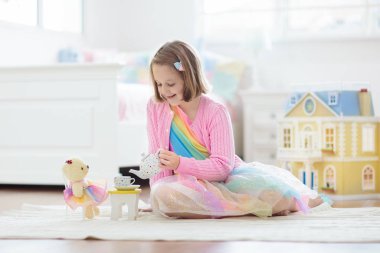 Bebek eviyle oynayan küçük bir kız. Oyuncaklı çocuk