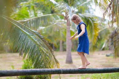 Kids on beam. Playground in tropical resort.