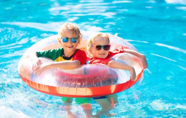 Kids in swimming pool. Life jacket for child.