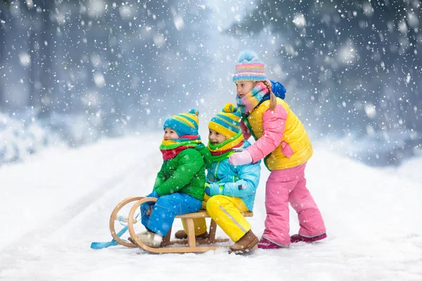 Τα παιδιά παίζουν στο χιόνι. Χειμώνας έλκηθρο βόλτα για παιδιά — Φωτογραφία Αρχείου