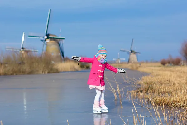 Pattinaggio su ghiaccio per bambini sul canale del mulino ghiacciato in Olanda . — Foto Stock