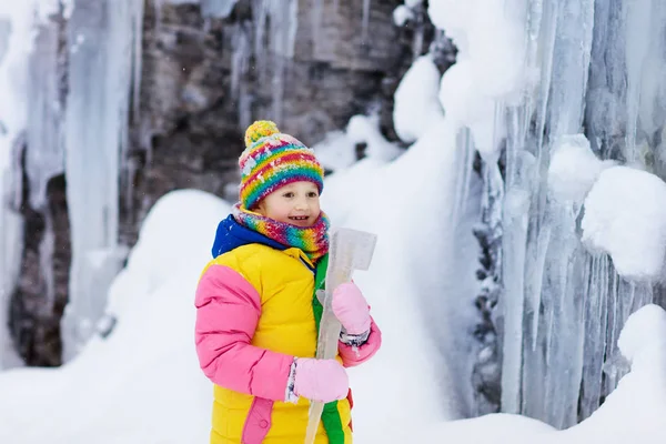 Children play with icicle in snow. Kids winter fun — 图库照片