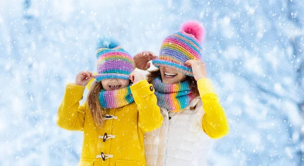 Mãe e criança em chapéus de inverno de malha na neve . — Fotografia de Stock