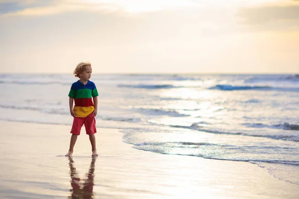 Παιδί που παίζει στην παραλία του ωκεανού. Παιδί στο ηλιοβασίλεμα στη θάλασσα. — Φωτογραφία Αρχείου