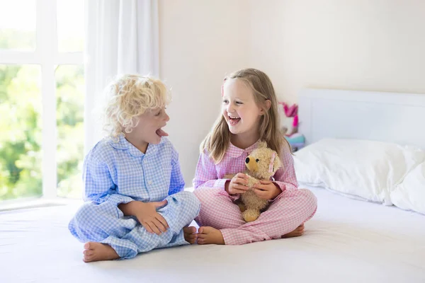 Miúdos na cama. Crianças de pijama. Quarto de família . — Fotografia de Stock