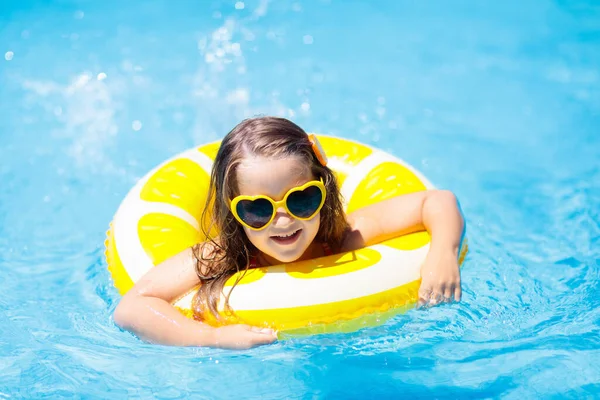 Anak kecil di kolam renang dengan mainan cincin. Anak-anak berenang . — Stok Foto