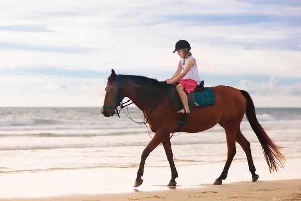 Plajda at sürme çocuklar. Çocuklar atlar binmek. — Stok fotoğraf