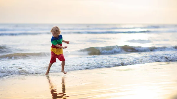 Kind spielt am Strand. Kind bei Sonnenuntergang Meer. — Stockfoto