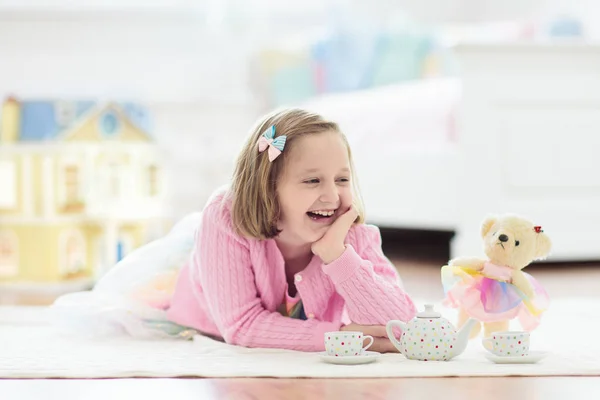 Маленька дівчинка грає з ляльковим будинком. Малюк з іграшками — стокове фото