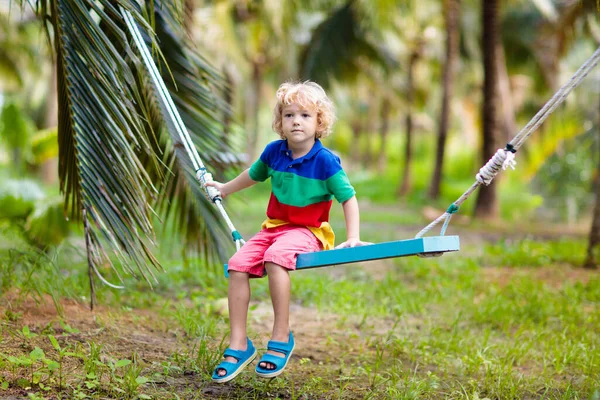 Niños en columpio. Parque infantil en resort tropical . —  Fotos de Stock