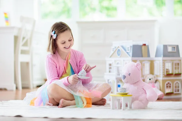 Ένα κοριτσάκι που παίζει με το κουκλόσπιτο. Παιδί με παιχνίδια — Φωτογραφία Αρχείου