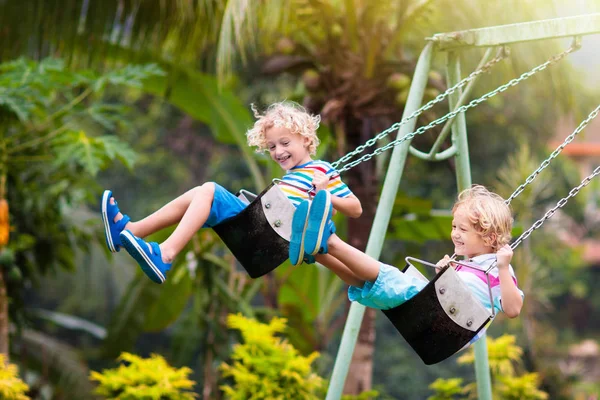 Kind op de speelplaats. Swing kinderen spelen buiten. — Stockfoto