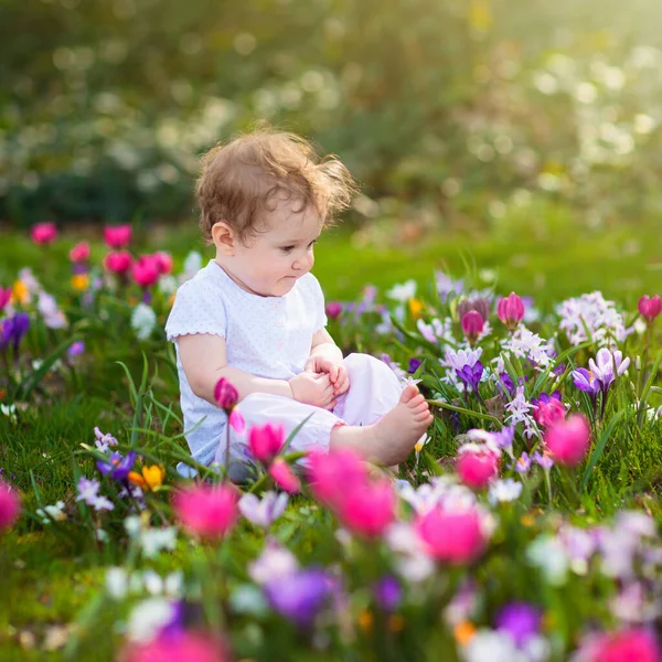 Criança no parque de primavera com flores — Fotografia de Stock