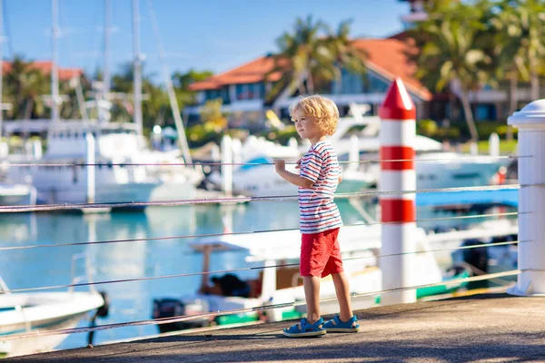 Kind kijken jacht en boot in de haven. Zeilen. — Stockfoto