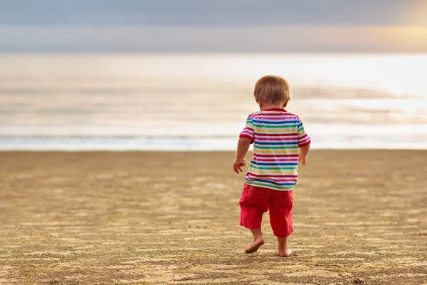 Child playing on ocean beach. Kid at sunset sea. — Stock Photo, Image