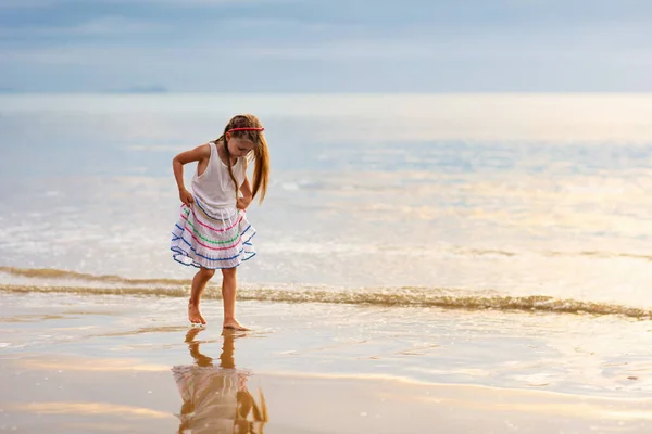 Kind spielt am Strand. Kind bei Sonnenuntergang Meer. — Stockfoto