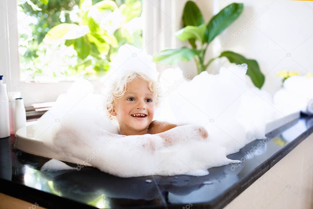 Child in bubble bath. Kid bathing. Baby in shower.