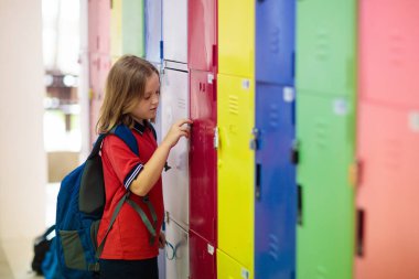Student in school at locker. Kids in preschool.