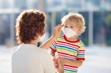 Mother and child with face mask and hand sanitizer