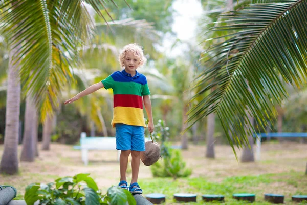 Niños en la viga. Parque infantil en resort tropical . — Foto de Stock
