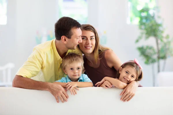 Happy family at home. Parents and kids on couch. — Stockfoto