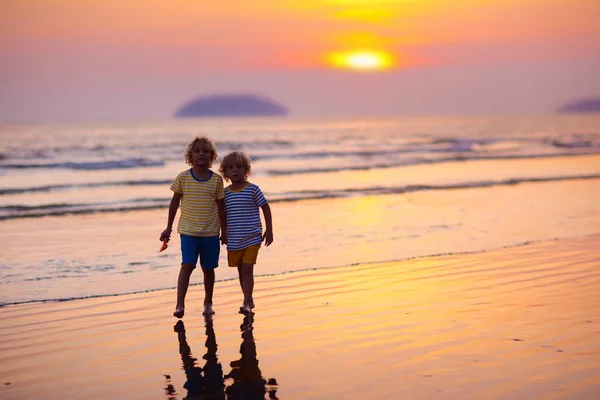 Dítě hrající na pláži u oceánu. Kluk na západu slunce moře. — Stock fotografie