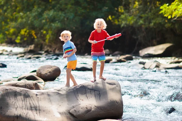 Escursioni per bambini in montagna. Bambini sulla riva del fiume . — Foto Stock