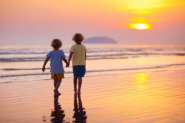 Enfant jouant sur la plage océanique. Enfant au coucher du soleil mer . — Photo