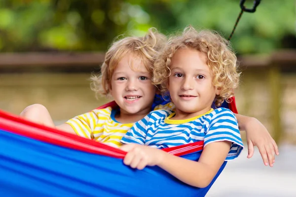Jongen in hangmat. Kinderen spelen in de zomertuin. — Stockfoto