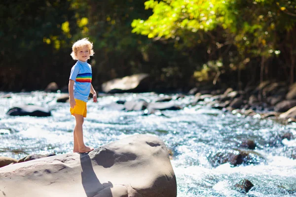 Senderismo infantil en las montañas. Niños en la orilla del río . —  Fotos de Stock