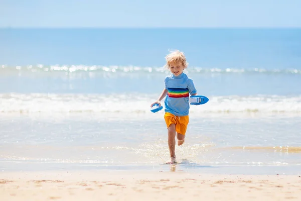 Niños jugando en la playa. Los niños juegan en el mar . —  Fotos de Stock