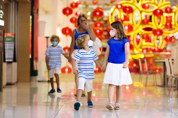 Familia usando mascarilla en centro comercial en Asia — Foto de Stock