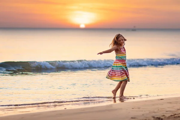 Bambino che gioca sulla spiaggia dell'oceano. Ragazzo al tramonto mare . — Foto Stock