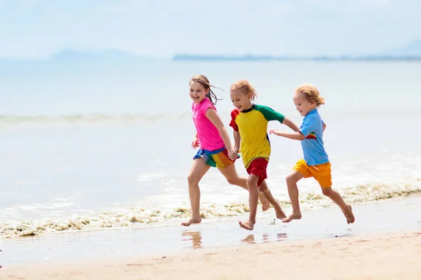 Niños jugando en la playa. Los niños juegan en el mar . —  Fotos de Stock