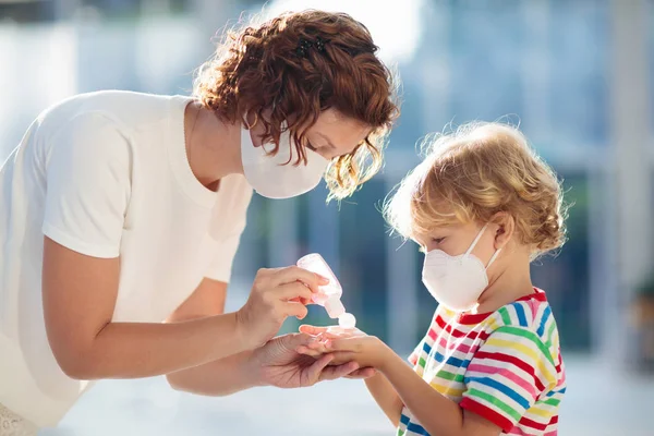 Mère et enfant avec masque facial et désinfectant pour les mains — Photo