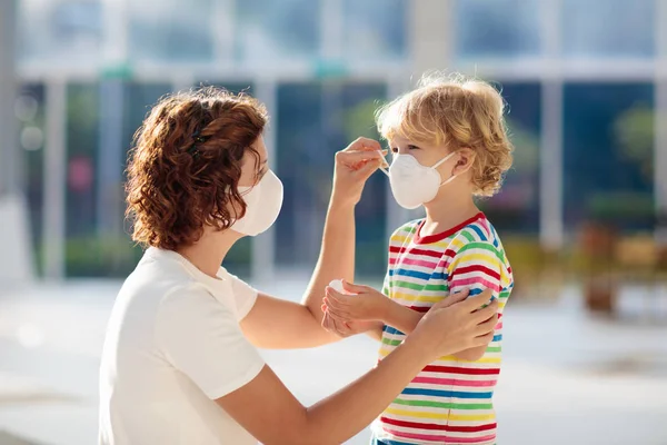 Mère et enfant avec masque facial et désinfectant pour les mains — Photo