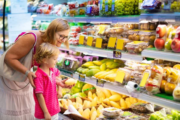 Matka i dziecko kupują owoce w supermarkecie. — Zdjęcie stockowe