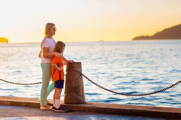 Mutter und Kind am Strand bei Sonnenuntergang. — Stockfoto