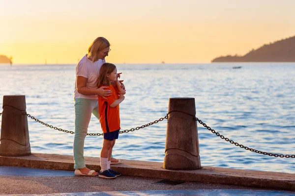 Mutter und Kind am Strand bei Sonnenuntergang. — Stockfoto