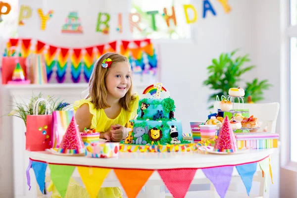 Fiesta de cumpleaños infantil. Los niños soplan vela en la torta . — Foto de Stock