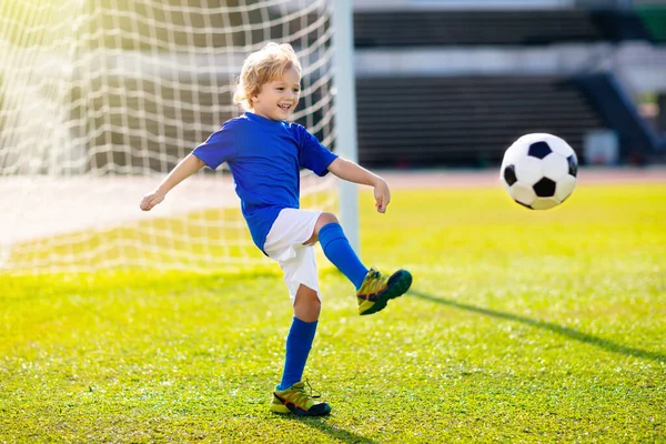 Los niños juegan al fútbol. Niño en el campo de fútbol . — Foto de Stock