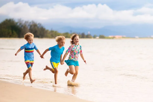 孩子们在热带海滩玩耍 孩子们在暑假时在海上游泳和玩耍 沙子和水的乐趣 防晒幼儿 小男孩和小女孩在海滨跑来跑去 — 图库照片