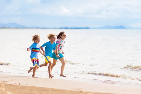 孩子们在热带海滩玩耍 孩子们在暑假时在海上游泳和玩耍 沙子和水的乐趣 防晒幼儿 小男孩和小女孩在海滨跑来跑去 — 图库照片