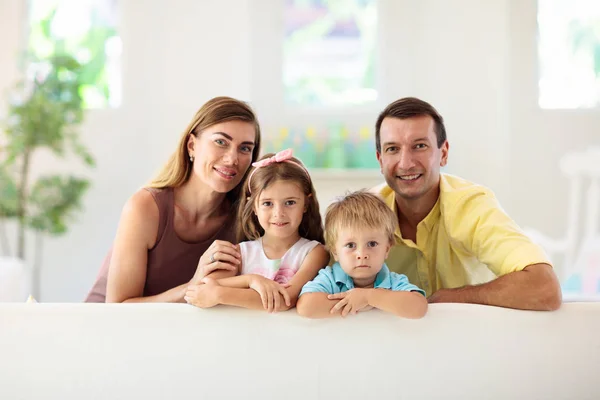 快乐的家庭在家里父母和孩子们坐在阳光灿烂的客厅里的白色沙发上 男孩和女孩一起玩 女儿和儿子在沙发上休息 — 图库照片