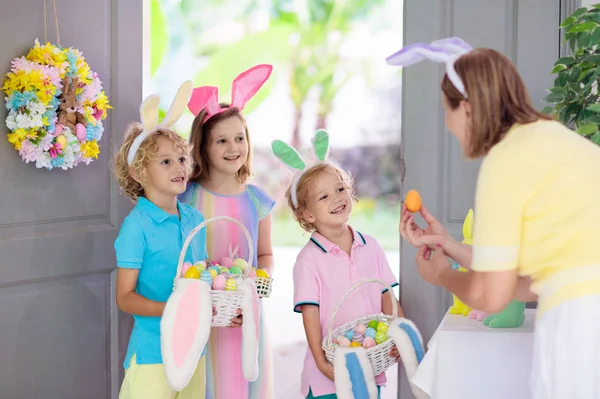 부활절 사냥하는 초콜릿 달걀로 바구니를 있는아이 부활절 기념행사가 현관문에 어린이들은 — 스톡 사진