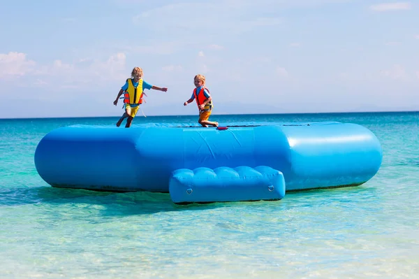 Παιδιά Που Πηδάνε Τραμπολίνο Τροπική Παραλία Παιδιά Πηδούν Φουσκωτό Νεροτσουλήθρα — Φωτογραφία Αρχείου